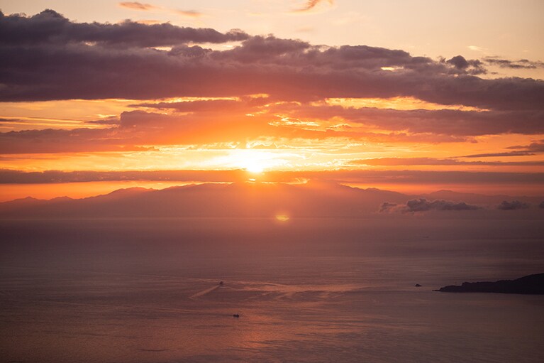 朝方、キラキラと輝く水面を進んでいく漁船。