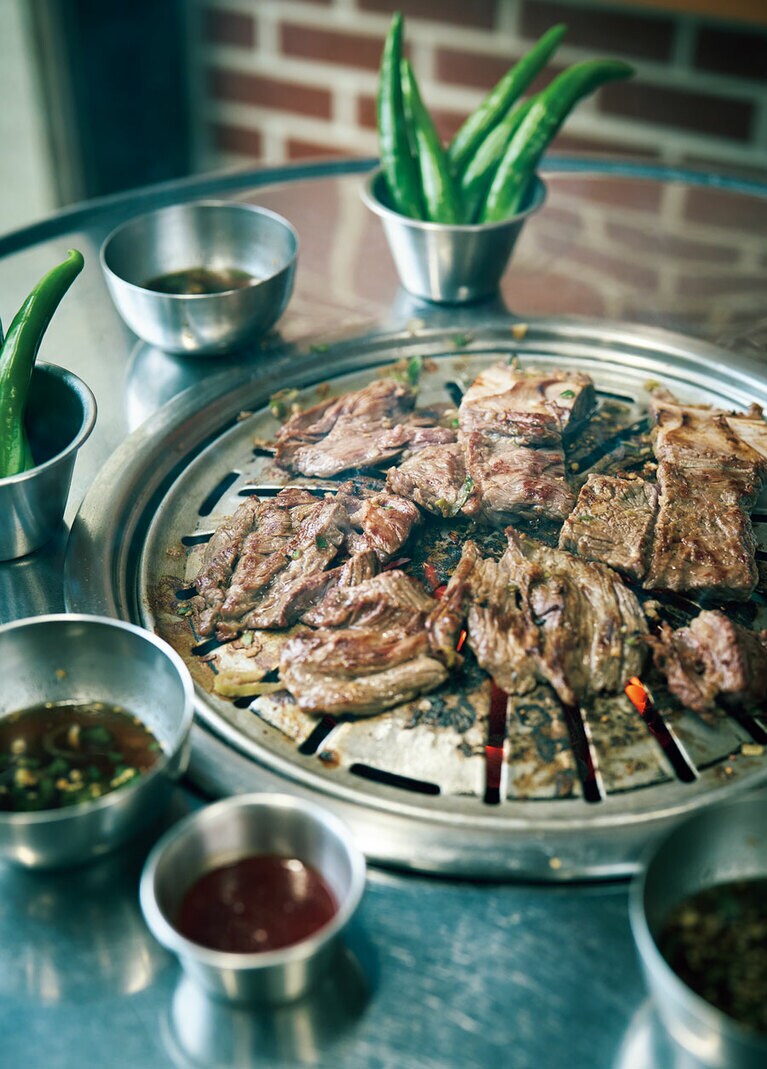 1人前150gの牛カルビW17,500。脂の少ない国産牛を中心に、オーストラリアや米国産も吟味して取り入れる。甘めのタレ、青唐辛子、ニンニク付き。