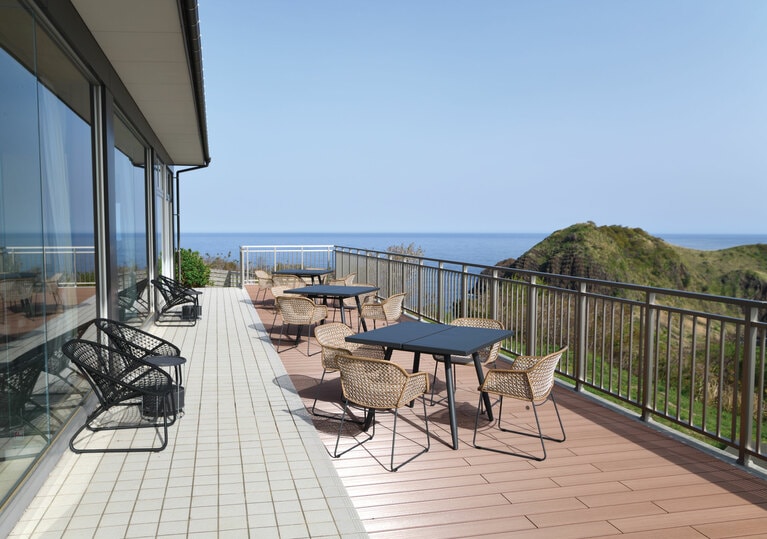 「二ツ亀」と美しい日本海が見渡せる開放感いっぱいのウッドデッキテラス。©SADO二ツ亀ビューホテル