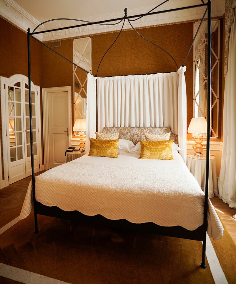 創業当時の温もりあるインテリアとアンティークで囲まれた“ヘリテージ・スイート・ヘルヴェティア”。白木枠の鏡扉や鉄細工の天蓋なども職人が丁寧に修復。