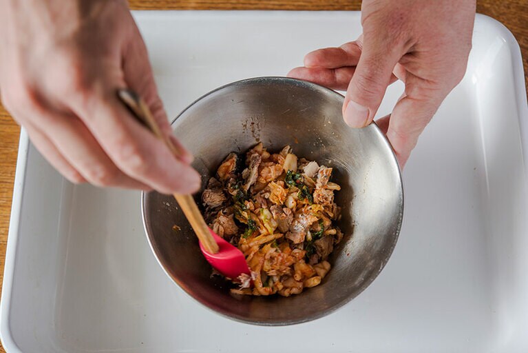 サバ缶の汁気を取り除き、ボウルに入れる。キムチを細かく刻み、ボウルに入れ、ごま油を加えてよくあえる。