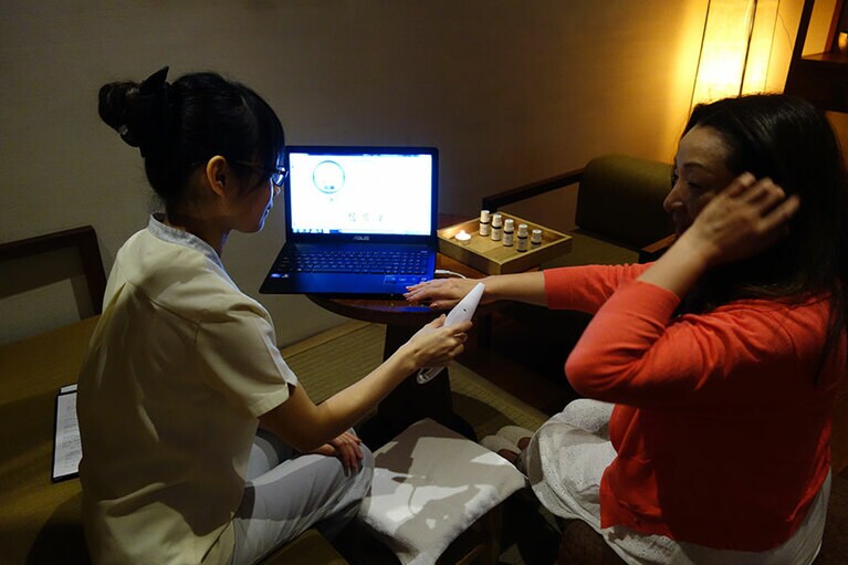 手と足のツボに機器をあてて五行経絡の状態を測定。