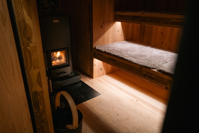 薪ストーブの様子を確認しながら、自分で薪を追加してサウナを温める。