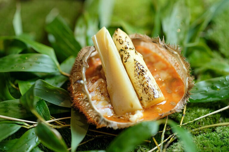 毛蟹の殻の中には、蟹の身と、宇治の「ひらがいたまごWABISUKE」の卵、刻んだホワイトアスパラガスのピクルスを合わせたトロトロのソース。主役の塚原の筍と佐賀のホワイトアスパラがのる。撮影＝橋本篤